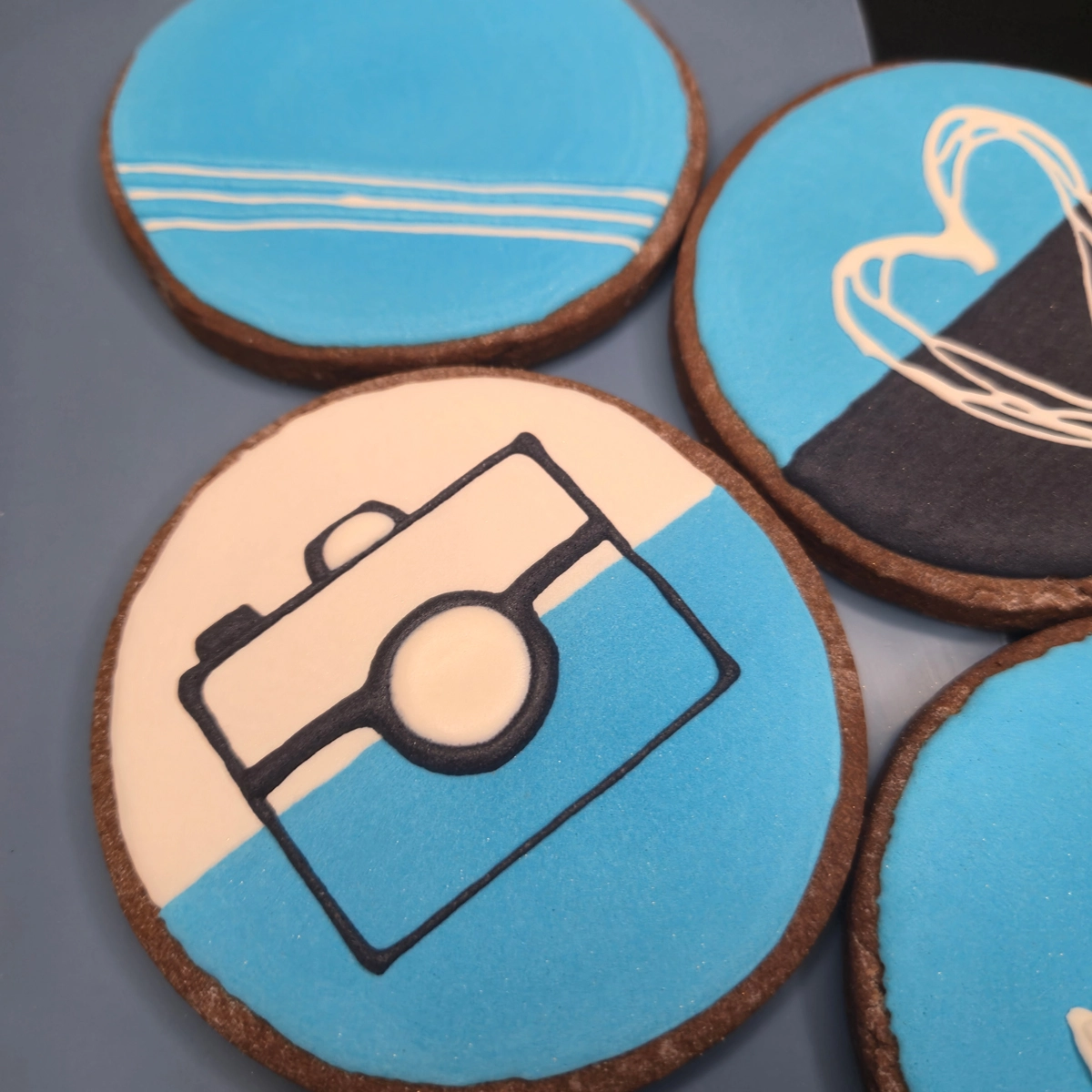 Bolachas de manteiga com cacau decoradas com glacê real com branding da empresa de fotografia Plumi. - Bolos de aniversário no Porto | Bento Cakes, Cake Design, Bolachas e Cupcakes | Porto | Sahri Dessert Art