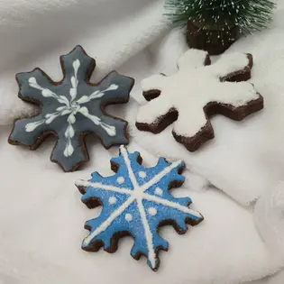 Três bolachas em forma de floco de neve decoradas com glacê real e açúcar granulado. - Bolos de aniversário no Porto | Bento Cakes, Cake Design, Bolachas e Cupcakes | Porto | Sahri Dessert Art