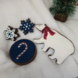 Quatro bolachas variadas de Inverno: dois flocos de neve, um urso polar com um cachecol e uma cana com riscas decoradas com glacê real. - Bolos de aniversário no Porto | Bento Cakes, Cake Design, Bolachas e Cupcakes | Porto | Sahri Dessert Art
