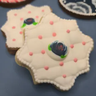 Duas bolachas em forma e textura de almofada com uma rosa azul escura no meio em glacê real ideiais para o Dia da Mãe. - Bolos de aniversário no Porto | Bento Cakes, Cake Design, Bolachas e Cupcakes | Porto | Sahri Dessert Art