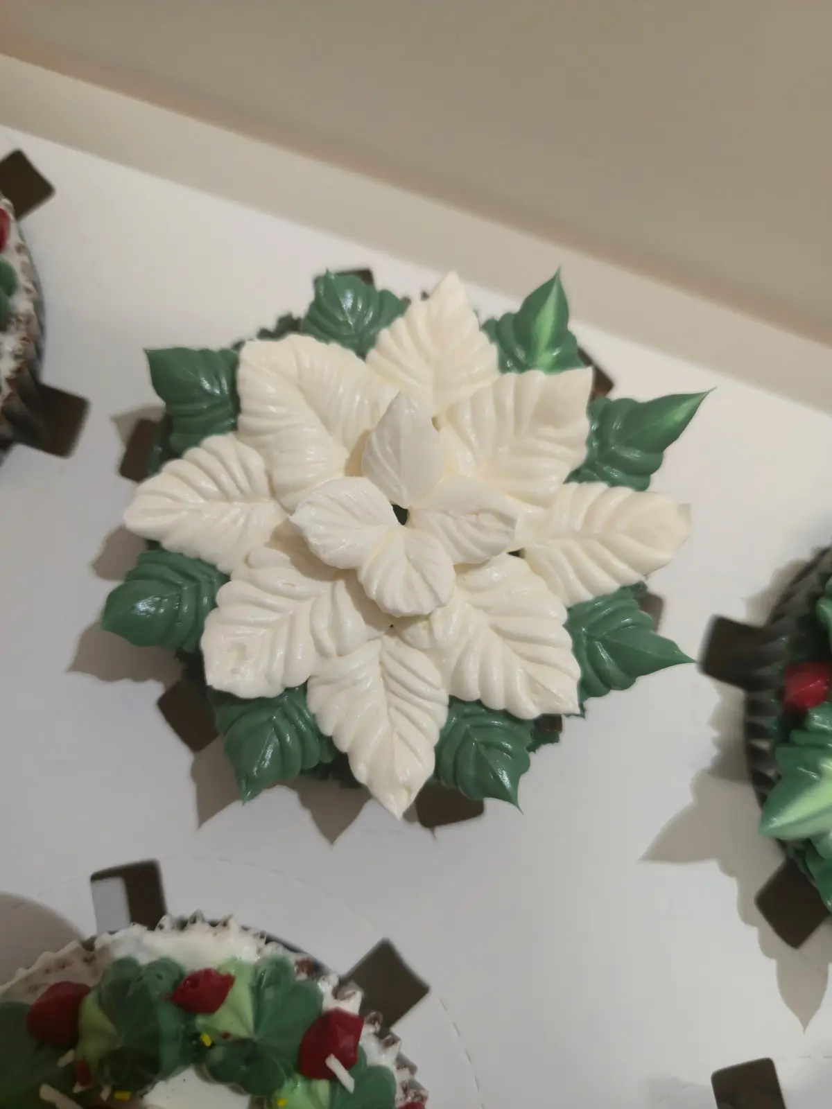 Cupcakes de chocolate decorados com motivos de Natal, como poinsettias e coroas de azevinho. - Bolos de aniversário no Porto | Bentô Cakes, Cake Design, Bolachas e Cupcakes | Porto | Sahri Dessert Art
