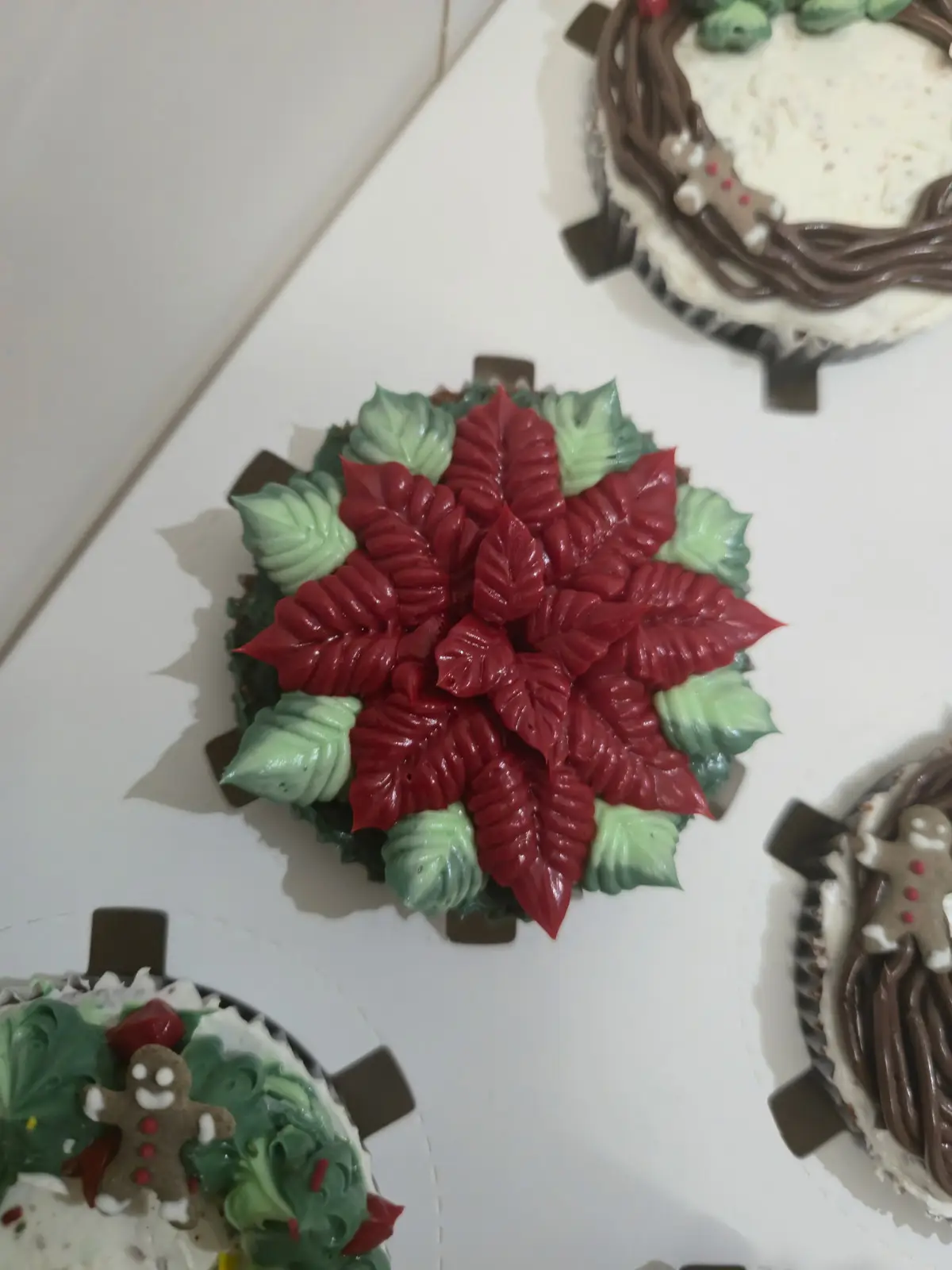 Cupcakes de chocolate decorados com motivos de Natal, como poinsettias e coroas de azevinho. - Bolos de aniversário no Porto | Bentô Cakes, Cake Design, Bolachas e Cupcakes | Porto | Sahri Dessert Art