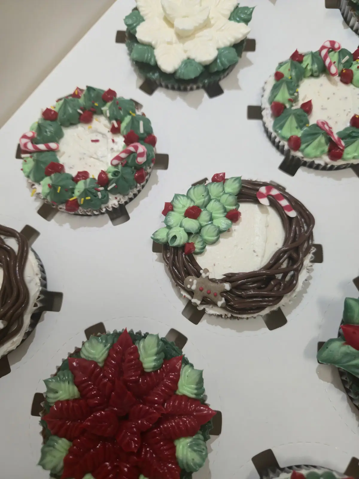 Cupcakes de chocolate decorados com motivos de Natal, como poinsettias e coroas de azevinho. - Bolos de aniversário no Porto | Bentô Cakes, Cake Design, Bolachas e Cupcakes | Porto | Sahri Dessert Art